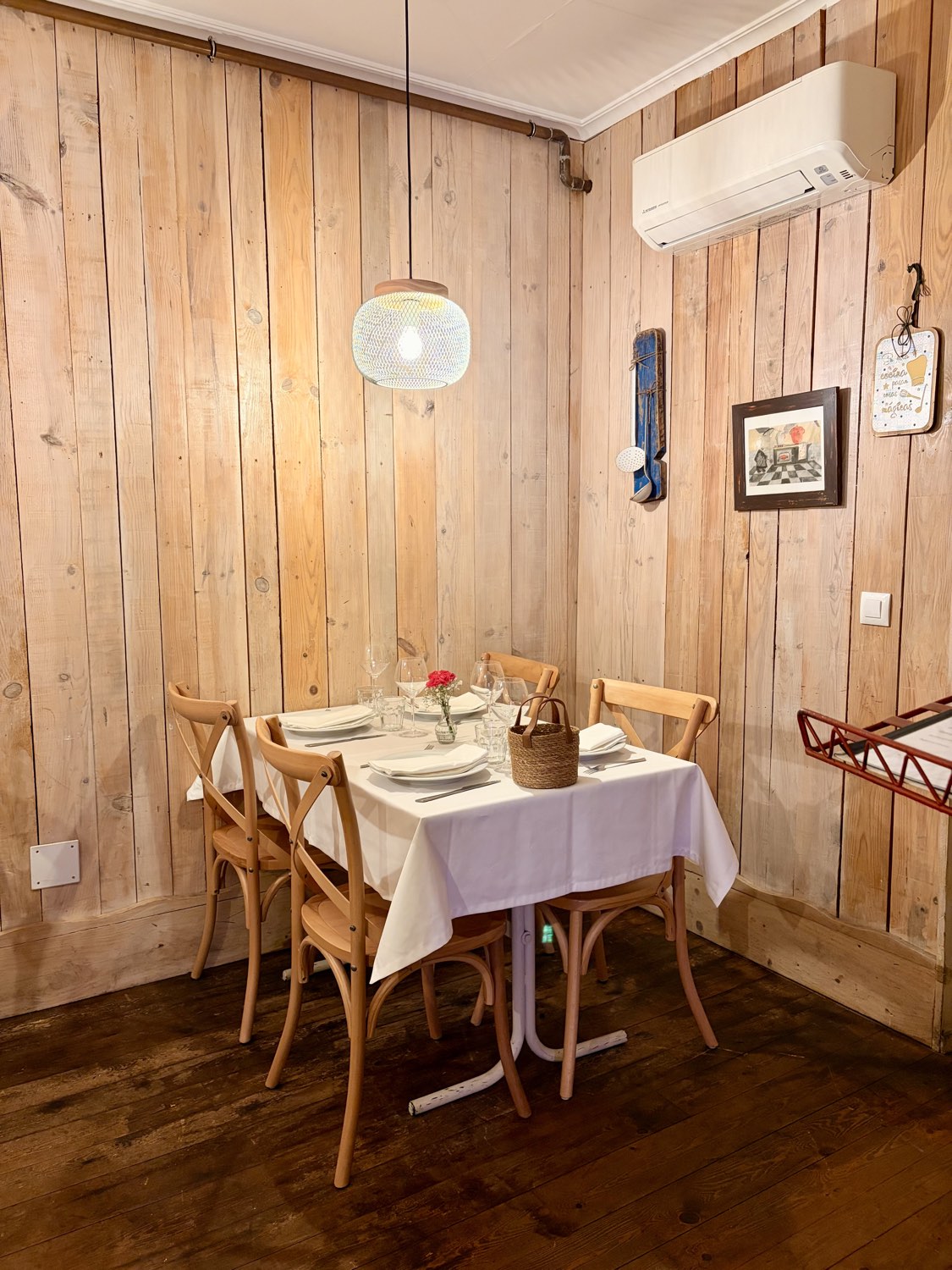 Comedor del restaurante La Frisona, con paredes de madera clara y mantel blanco