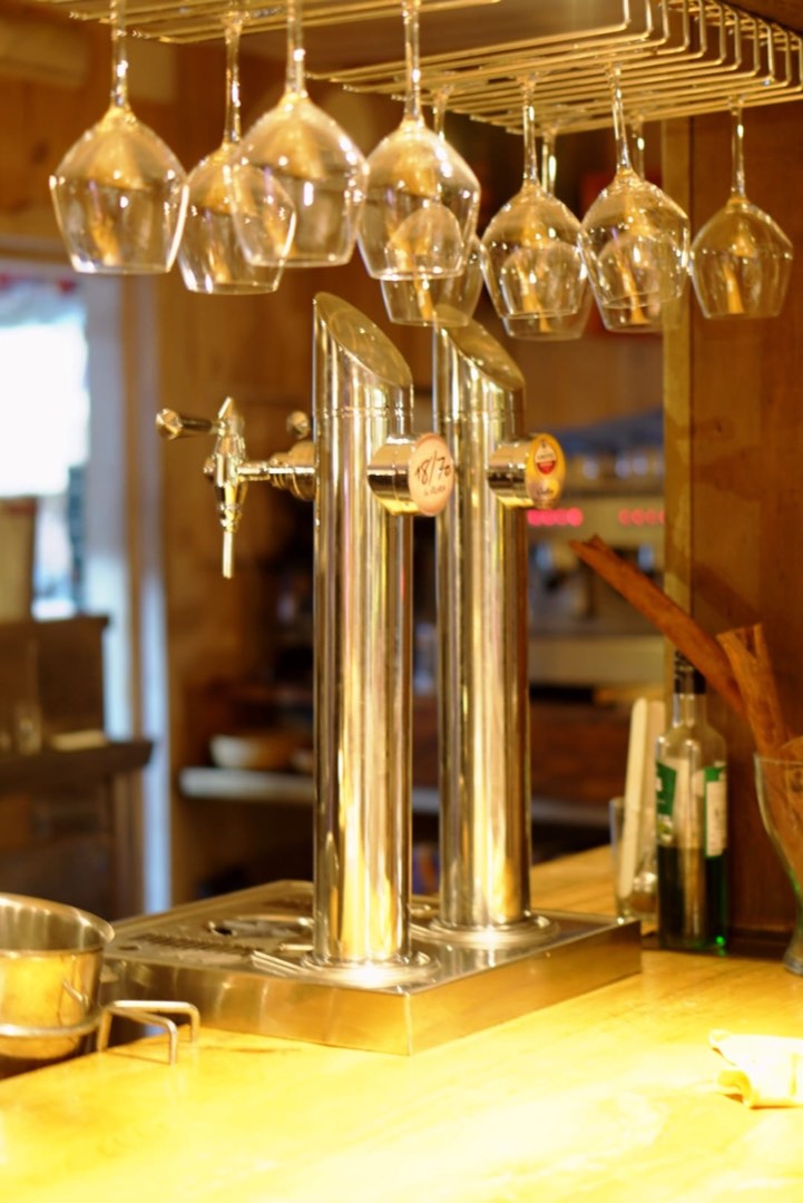 Tiradores de cerveza y copas colgadas sobre la barra